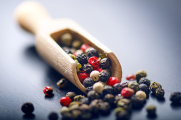 Colorful spices on a dark blue table. Concept of kitchen and cooking. Spicy on a wooden spoon. 