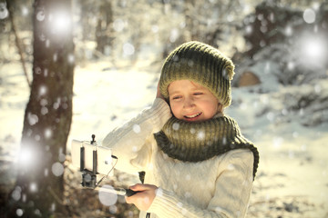 Девочка фотографирует себя на телефон в зимний снежный день.