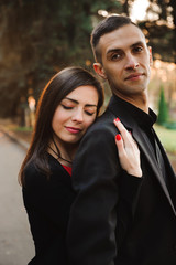 Young couple holding hands, smile and walk in the park in one au