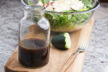 a glass bottle with salad dressing consisting of balsamic vinegar, honey and olive oil
