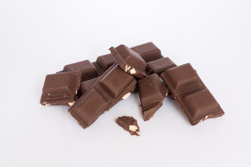  A few cubes of dark chocolate chunks pieces on white background
