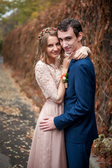 Portrait of happy newlyweds in autumn nature. Happy bride and gr