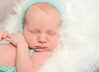 funny asleep baby face in hat, closeup