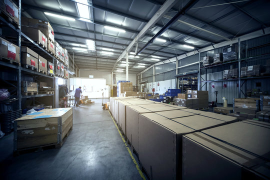 warehouse interior with paper boxes and worker with forklift in blue vintage color tone