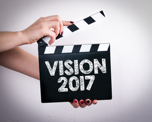 Vision 2017. Female hands holding movie clapper. 