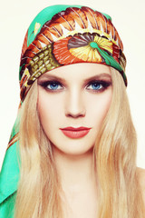 Portrait of young beautiful woman with long hair and stylish smoky eyes make-up in green silk scarf