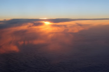 Fototapeta na wymiar Aerial view of a cloudy sunset while flying above the clouds