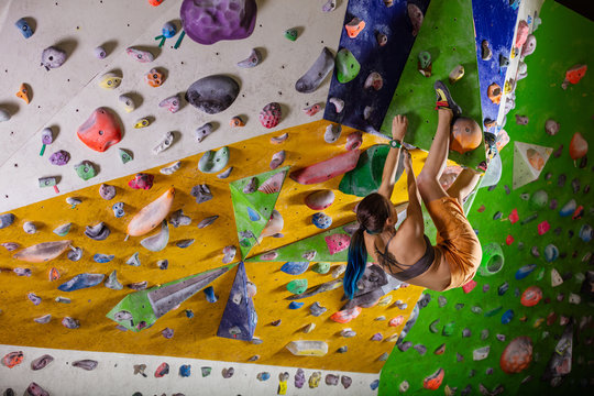 Young woman bouldering in climbing gym 