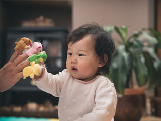 Happy baby girl play puppets with mom