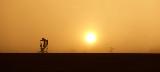 Pump Jack in Setting Sun and Sandstorm