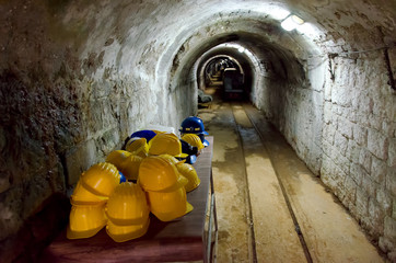 Table with yellow hard hats at entrance to a mine