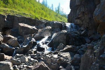 Waterfall among the rocks on the Putorana plateau.