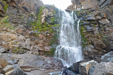 Obraz premium Waterfall among the rocks on the Putorana plateau.