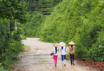 Fototapeta premium Three girls on their way to work in Vietnam