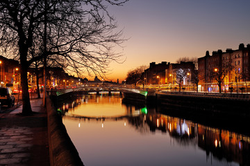 Fototapeta premium Ha'penny Bridge and the north banks of the river Liffey in Dublin City Centre at night. Ha'penny Bridge is a pedestrian bridge built in 1816 of cast iron