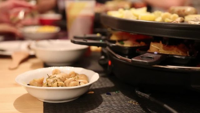 Gruppe von Freunden genie&szlig;t Raclette an Silvester