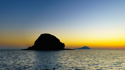 Fototapeta na wymiar Sunset at Pollara (Salina) looking towards ships and Filicudi an