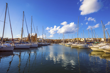 Fototapeta na wymiar Msida, Malta - Yacht marina with blue sky and nice clouds on a summer day