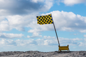 Lifeguard flag on beach with stormy sky at Mission Beach in San Diego, California.  