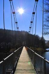 Panele Szklane  Most wiszący na tle słonecznego nieba