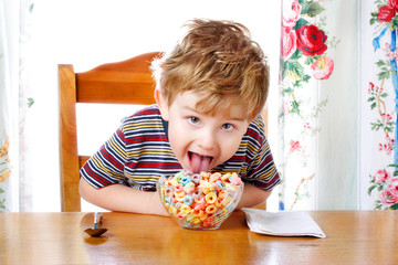 Boy tasting colorful cereal
