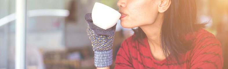 woman hands holding mug of hot drink that standing on wooden table