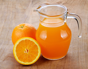 Fototapeta na wymiar Orange juice and slices on wood