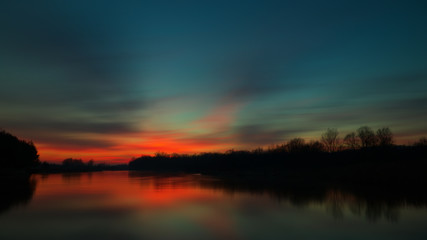 Fototapeta na wymiar Zimowy zachód słońca / Zimowy, grudniowy zachód słońca w dolinie Pilicy odzwierciedlony w jej wodach. 