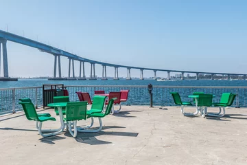 Photo sur Plexiglas Jetée Dining area on the viewing pier at Cesar Chavez Park in San Diego, California, with Coronado bridge in the background.