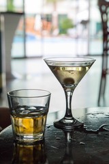 Martini glass and whiskey on the table