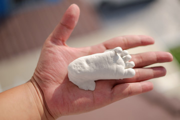 Plaster baby feet on hand