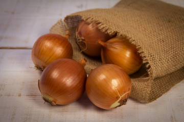 Onion in a bag on wooden background