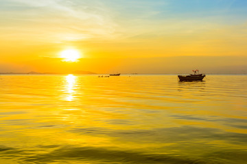Fototapeta na wymiar Beach and boat with warm light sunset background