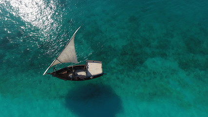 Beautiful white sailboat in sea, traditional boat dhow Zanzibar, aerial view,shooting with the drone.