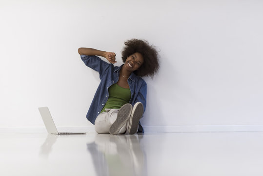 african american woman sitting on floor with laptop