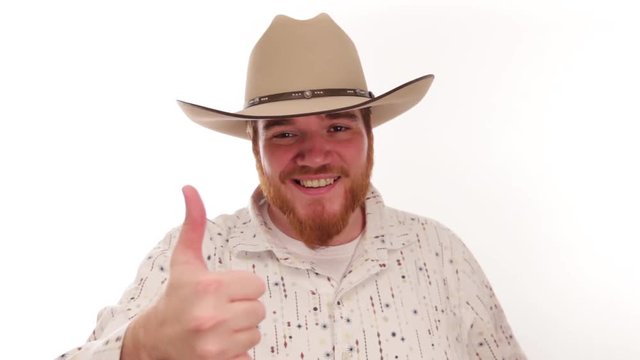 Hipster millennial cowboy putting on his cowboy hat and smiling, thumbs up