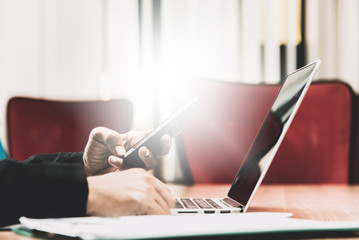Close up of businessman working in his office with smart phone,d