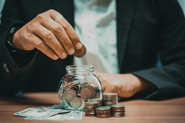 Close up of business man hand putting the coins on the table in