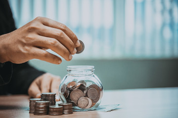 Close up of business man hand putting the coins on the table in