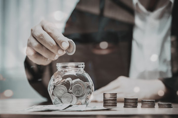 Close up of business man hand putting the coins on the table in