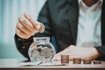 Close up of business man hand putting the coins on the table in