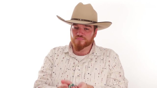 Hipster millennial cowboy showing handfull of poker chips
