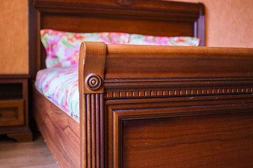 wooden bed with carved elements on the back