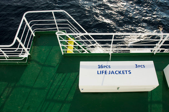 Two white boxes with life jackets on deck of passenger liner
