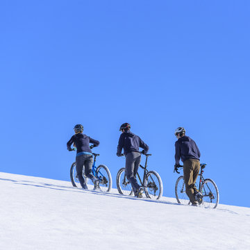 Radfahrer schieben ihr Rad im Schnee bergauf