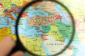 Syria on the world map with a magnifying glass