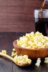 Popcorn in a bowl on wooden background.