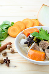 Beef and vegetables soup in bowl on wooden background