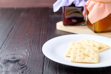 Crackers on a plate on wooden background.
