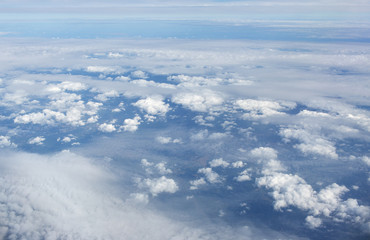 Aerial view on clouds and blue sky from airplane window
